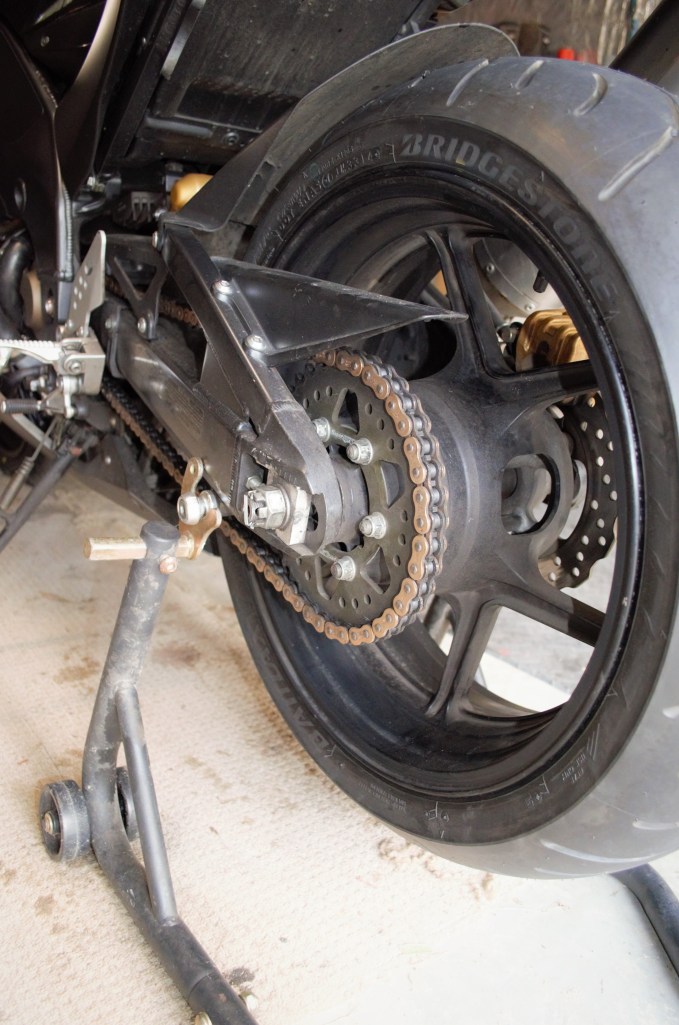 First of all, pop your bike on a rear stand or its centre stand if it has one