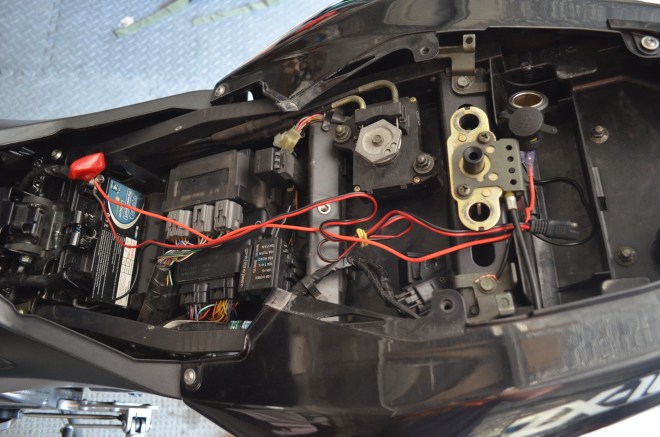 Gain access to your motorcycles battery. My ZX10 involves removing the rear seat cowl, a small panel then finally the seat. Find out where you want your port. In my case I want it under the pillion seat. Feed the positive cable through to your battery. For your negative you want to ground it to your frame.